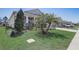 Landscaped front yard with lush grass and palm trees adding curb appeal at 7889 Penrose Pl, Wildwood, FL 34785