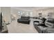 Spacious living room featuring tile floors, modern furniture, and an open-concept design into the kitchen area at 7889 Penrose Pl, Wildwood, FL 34785