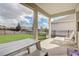 Rear covered patio with white table and chairs overlooking fenced yard at 7889 Penrose Pl, Wildwood, FL 34785