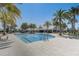 Community pool with ample seating surrounded by tall palm trees creating a tranquil tropical oasis at 7889 Penrose Pl, Wildwood, FL 34785