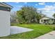 Exterior view of the home featuring a concrete tile patio, and large grassy yard at 801 W Anderson St, Orlando, FL 32805