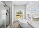 Bright bathroom featuring modern shower, soaking tub, and double window at 801 W Anderson St, Orlando, FL 32805