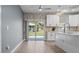 Open kitchen with stainless appliances, white cabinets, quartz countertops, and sliding glass doors to backyard at 801 W Anderson St, Orlando, FL 32805