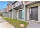 Modern townhome entrance with sleek door, patio, and well-manicured lawn at 3245 Sustainable Way, Kissimmee, FL 34747
