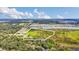Aerial view shows a mix of green fields and natural growth near a residential area and a lake, outlined in white at 4750 Rummell Rd, St Cloud, FL 34771