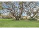Charming yellow home with mature trees and Spanish moss, surrounded by an expansive, well-maintained lawn at 4750 Rummell Rd, St Cloud, FL 34771