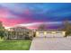 Charming home with a four-car garage and screened-in lanai, beautifully illuminated at dusk, creating a welcoming ambiance at 4750 Rummell Rd, St Cloud, FL 34771