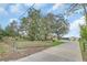 Well-maintained property featuring a quaint yellow home, a long driveway, and lush green lawns at 4750 Rummell Rd, St Cloud, FL 34771