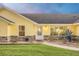 Charming single-story yellow home featuring stone accents, a well-manicured lawn, and beautiful landscaping at 4750 Rummell Rd, St Cloud, FL 34771