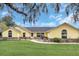 Inviting yellow home with stone accents, arched windows, and manicured lawn at 4750 Rummell Rd, Saint Cloud, FL 34771