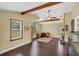 Warm and inviting living room with wood floors, exposed beams, and natural light from large windows at 4750 Rummell Rd, St Cloud, FL 34771