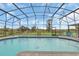 Daytime view of screened pool with lounge chairs and green field view at 4750 Rummell Rd, St Cloud, FL 34771