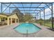 Wide, exterior view of a screened pool with backyard, lounge chairs, and covered patio at 4750 Rummell Rd, St Cloud, FL 34771