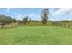 A spacious green lawn is enclosed by a wooden fence with mature trees in the background at 4750 Rummell Rd, St Cloud, FL 34771