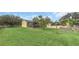 Exterior shot of a house with a large yard, mature trees, a detached garage, and a small screened porch at 4750 Rummell Rd, St Cloud, FL 34771