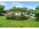 Charming single-story home with lush landscaping, palm trees and vibrant flower beds in a verdant front yard at 4908 Seminole Ave, Winter Park, FL 32792