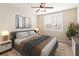 Cozy bedroom with neutral tones, a ceiling fan, and a comfortable bed with stylish throw blanket and abstract art at 8677 Pinter St, Orlando, FL 32827