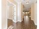 Hallway with wood tile floors and white trim, open to a living space with stairs in view at 8677 Pinter St, Orlando, FL 32827
