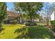 Inviting front yard with a well-kept lawn, garden beds, and a mature tree providing shade at 8677 Pinter St, Orlando, FL 32827