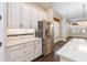 Bright kitchen with a stainless steel refrigerator, white cabinets and quartz countertops at 8677 Pinter St, Orlando, FL 32827