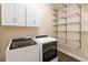 Functional laundry room with washer, dryer, and ample shelving at 8677 Pinter St, Orlando, FL 32827