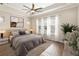 Serene bedroom with tray ceiling, a ceiling fan, and three windows providing natural light at 8677 Pinter St, Orlando, FL 32827