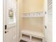 Practical mud room area featuring a storage bench, coat hooks, and natural lighting at 8677 Pinter St, Orlando, FL 32827