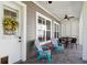 Charming covered patio with comfortable seating, ceiling fan, and inviting entrance with a wreath at 8677 Pinter St, Orlando, FL 32827