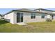 Rear view of house showcasing sliding glass doors and lawn at 2106 Rosewood Dr, Bartow, FL 33830