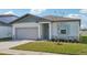 Newly built home with gray siding, light green accents, and well-manicured lawn at 2149 Rosewood Dr, Bartow, FL 33830