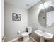 Bright bathroom with ceramic tile floor, pedestal sink, and decorative wall art at 3529 Sanctuary Dr, St Cloud, FL 34769