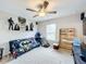 Bedroom with ceiling fan, carpeted floors, and unique Batman-themed decor displayed on a shelf at 3529 Sanctuary Dr, St Cloud, FL 34769
