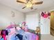 Vibrant bedroom featuring a playful decor, ceiling fan, and ample closet space at 3529 Sanctuary Dr, St Cloud, FL 34769