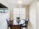 Cozy dining area with wood table, leather chairs, natural light from a large window and a wall-mounted television at 3529 Sanctuary Dr, St Cloud, FL 34769