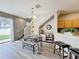 Bright dining area with wood floors, modern table, and decorative display case next to kitchen at 3529 Sanctuary Dr, St Cloud, FL 34769
