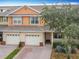 Townhouse with a two-car garage, brick accents, manicured landscaping, and a welcoming entrance at 3529 Sanctuary Dr, St Cloud, FL 34769