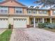 Charming townhouse showcasing a two-car garage, brick accents, and a well-maintained garden at 3529 Sanctuary Dr, St Cloud, FL 34769