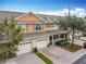 Multi-unit townhouse complex with two-car garages, brick features, and mature trees at 3529 Sanctuary Dr, St Cloud, FL 34769