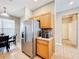 Open kitchen featuring stainless steel refrigerator, tile flooring and plentiful wood cabinets at 3529 Sanctuary Dr, St Cloud, FL 34769