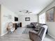 Comfortable living room with large windows, plush seating, ceiling fan, and neutral color palette at 3529 Sanctuary Dr, St Cloud, FL 34769