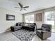 Inviting living room featuring a ceiling fan, cozy sectional, and bright natural light at 3529 Sanctuary Dr, St Cloud, FL 34769