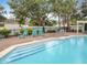Community pool with lounge chairs offers a relaxing outdoor retreat, surrounded by lush landscaping and mature trees at 3529 Sanctuary Dr, St Cloud, FL 34769
