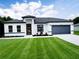 Beautiful single-story home featuring a well-manicured lawn, neutral paint scheme, and attached two-car garage at 16050 Sw 21St Ct, Ocala, FL 34473