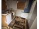 Kitchen under renovation with a double sink, peeling wallpaper, and boarded windows at 1805 W 15Th St # 1/2, Sanford, FL 32771