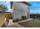 Side view of home with partial privacy fence, manicured landscaping, and walkway at 2201 Delaney. Ave, Orlando, FL 32806