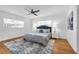Cozy bedroom with hardwood floors, neutral color scheme, ceiling fan, and bright windows at 2201 Delaney. Ave, Orlando, FL 32806