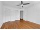 Bright bedroom features hardwood floors, ceiling fan, white walls and trim, with 2 sets of closet doors at 2201 Delaney. Ave, Orlando, FL 32806