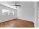 Bedroom with hardwood floors, large window, white walls, ceiling fan, and white trim at 2201 Delaney. Ave, Orlando, FL 32806