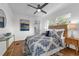 Bright bedroom with a ceiling fan, wood floors, and patterned bedding at 2201 Delaney. Ave, Orlando, FL 32806