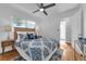 Comfortable bedroom featuring wood floors, natural light, and modern ceiling fan at 2201 Delaney. Ave, Orlando, FL 32806